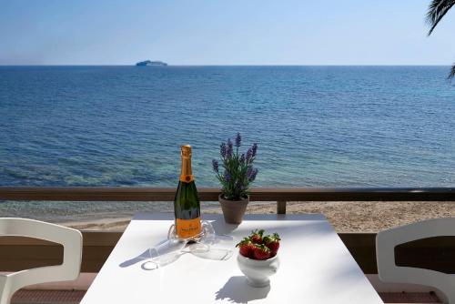 a table with a bottle of wine and a bowl of flowers at Enkala Apartamentos in Ibiza Town