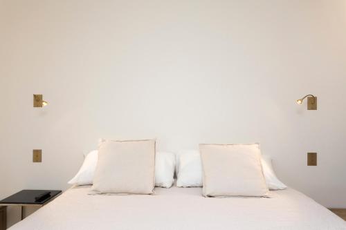 a white bed with white pillows on it at Foch triomphe in Paris