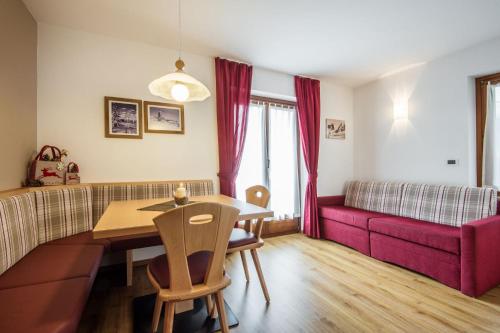 a living room with a table and a couch at Garnì Piz da L'Ander in Corvara in Badia