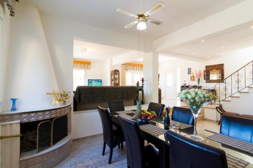 a dining room with a table and chairs and a couch at Aris Palace in Elia