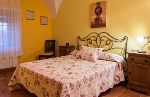 1 dormitorio con 1 cama con colcha rosa en Casa Rural El Fuentarro, en Botija
