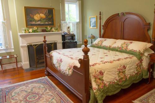 1 dormitorio con 1 cama y chimenea en Olde Town Inn, en Augusta