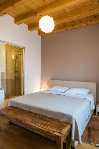 a bedroom with a large bed and a wooden bench at Pelegrin Apartment in Zadar