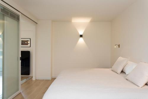 una camera con un letto bianco e una luce sul muro di Foch triomphe a Parigi
