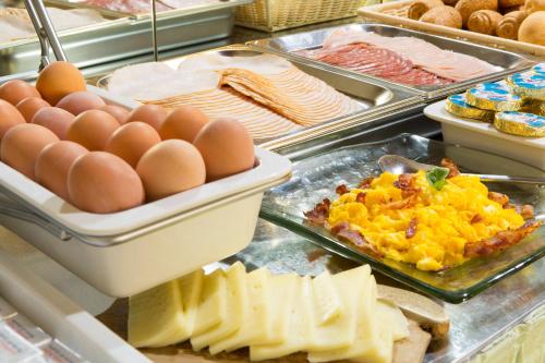 a buffet filled with eggs and cheese and other foods at Hotel Orto de' Medici in Florence