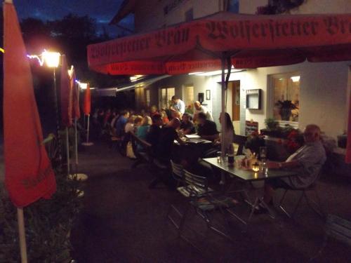 a group of people sitting at a restaurant at night at Gasthaus Zehrermühle in Schönberg