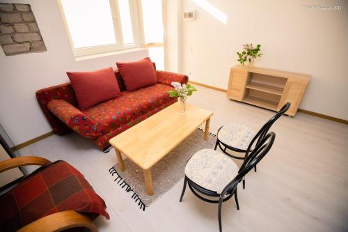 a living room with a couch and a table and chairs at Old Town Apartments in Alytus