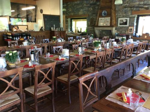 comedor grande con mesas y sillas de madera en La Meiro, en Castelmagno