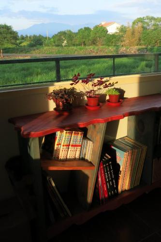 a wooden table with potted plants on a balcony at Mei Shiou B&B in Dongshan
