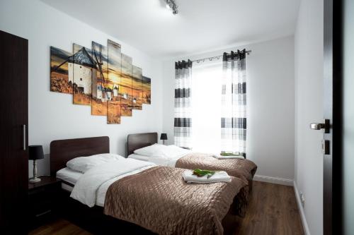ポズナンにあるJulia Apartments Poznańのベッドルーム1室(ベッド2台、窓付)