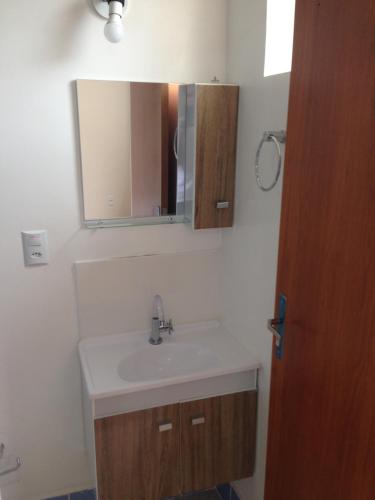 a bathroom with a sink and a mirror at Hostel Araucaria in Ribeirão Preto