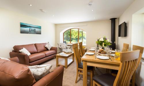 a living room with a table and a couch at Hill Of Oaks in Windermere