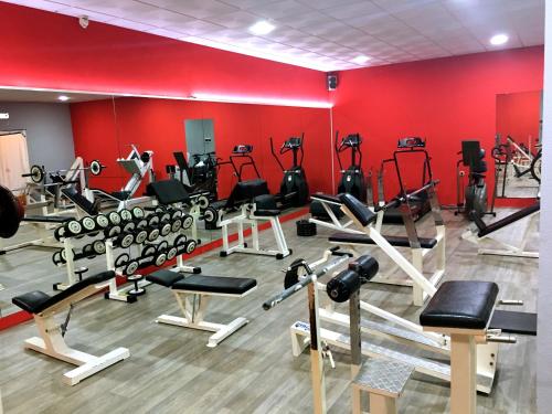 a gym with lots of exercise equipment in a red wall at First Flatotel International in Benalmádena