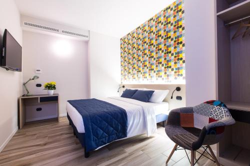 - une chambre avec un lit et une peinture colorée sur le mur dans l'établissement Aparthotel Isola, à Milan