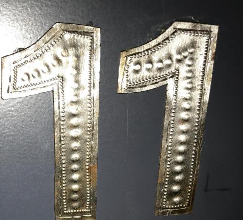 a metal letter t on a wall with beads at LOGIS Hotel-Restaurant Le Relais d'Aligre in Châteauneuf-en-Thymerais