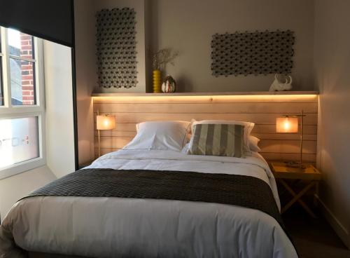 a bedroom with a large bed with two pillows at LOGIS Hotel-Restaurant Le Relais d'Aligre in Châteauneuf-en-Thymerais