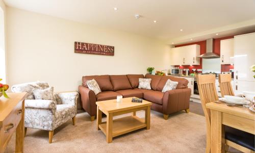 a living room with a couch and a table at Hill Of Oaks in Windermere