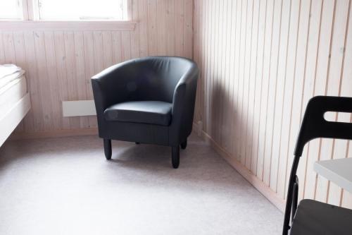 a black chair sitting in a corner of a room at Asaa Camping & Cottages in Aså