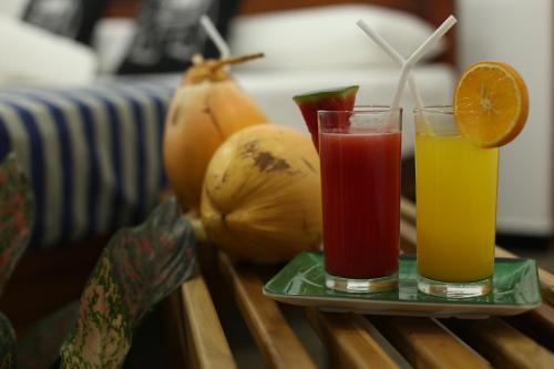 two glasses of juice on a table with fruit at Amsterdam Tourist Rest in Anuradhapura
