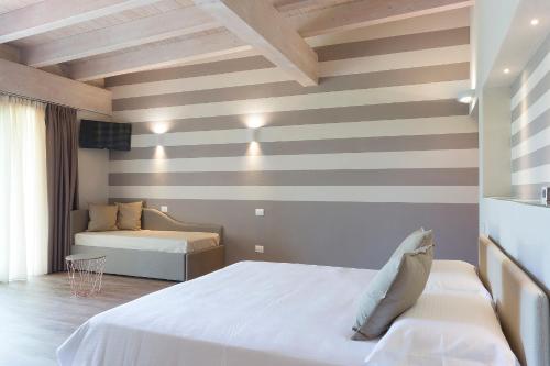 a bedroom with two beds and a striped wall at Il Sambuco Innamorato in Acqui Terme