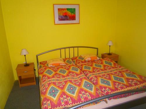 ein Bett mit einer bunten Bettdecke und zwei Nachttischen in der Unterkunft Apartman Springerovi in Slavonice
