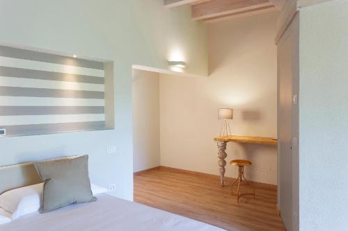 a bedroom with a bed and a desk in it at Il Sambuco Innamorato in Acqui Terme