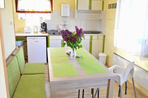 uma cozinha com uma mesa com um vaso de flores em Florianus Vendeghaz em Berekfürdő