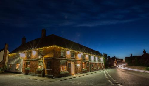 um edifício com luzes ao lado de uma rua em The Angel Inn, Stoke-by-Nayland em Stoke by Nayland