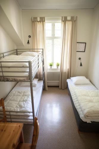 two bunk beds in a room with a window at Ronneby Brunnspark Vandrarhem och B&B in Ronneby