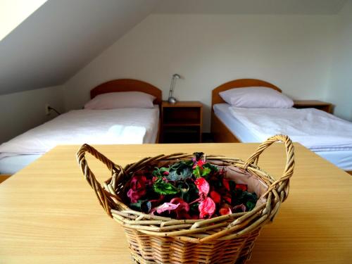 a basket of flowers sitting on a table with two beds at JI APARTMENT crossroads D1,D2,D52 in Modřice