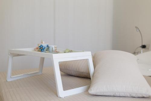 a white table with a pillow next to a white couch at Casa Rosanna in Maiori