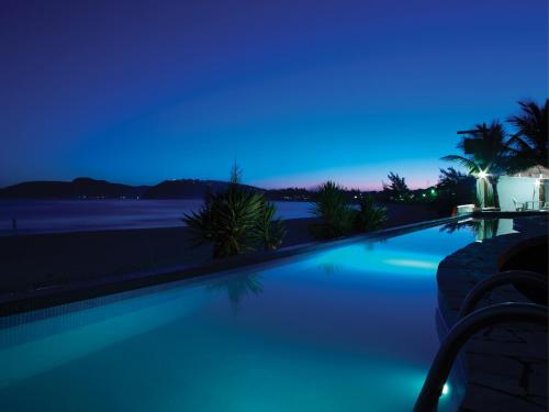 a swimming pool at night with a blue sky at Chez Pitu Praia Hotel in Búzios