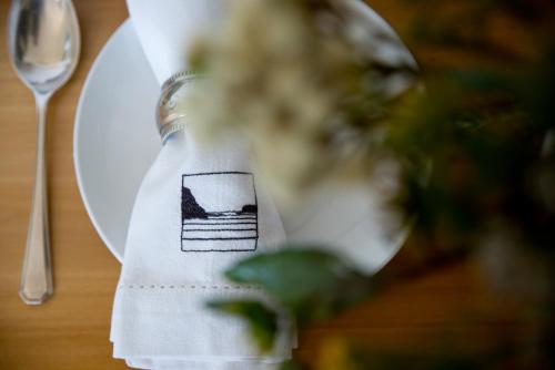 a white plate with a napkin on a table with a fork at Candlewood Lodge in Knysna