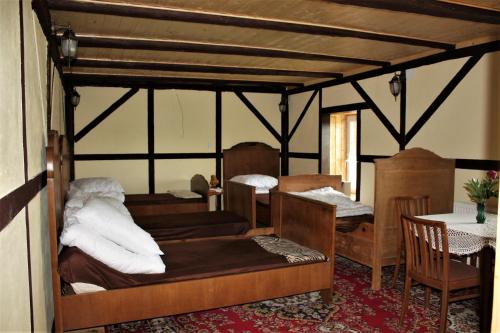 a room with a bed and a table and chairs at Gospodarstwo Agroturystyczne Powierzówka in Leśna