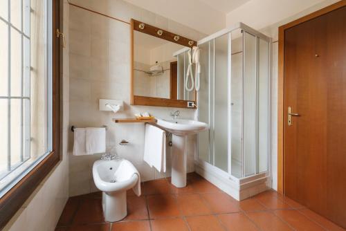a bathroom with a sink and a toilet and a mirror at La Corte di Lurago in Lurago D'Erba 