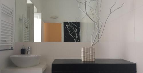 a bathroom with a sink and a vase on a table at Villa Branca Jacinta in Sintra