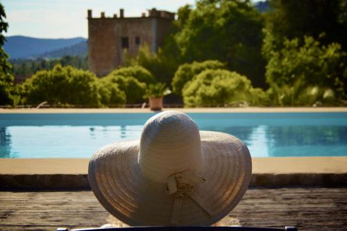 un sombrero de paja sentado junto a una piscina en Agroturismo Son Boronat, en Calviá