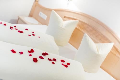 a bed with red hearts on the sheets at Hotel-Garni Weidacherhof in Leutasch