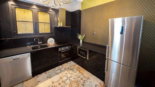 a kitchen with a stainless steel refrigerator and a window at Groc Rooms in La Seu d'Urgell