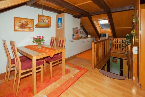 cocina y comedor con mesa de madera y sillas en Ferienwohnung Gottlöber, en Stadt Wehlen