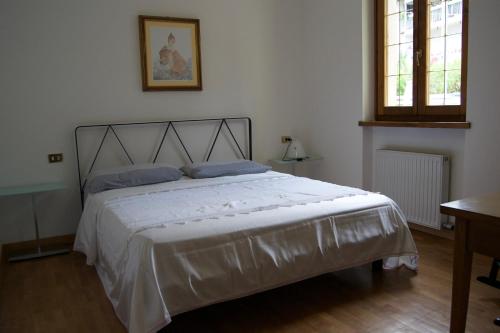 a bedroom with a large white bed in a room at Appartamento Marocche in Nago-Torbole