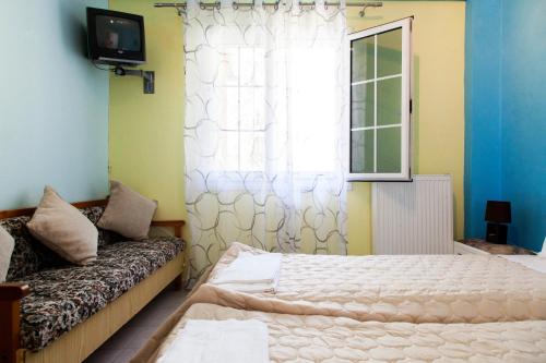 a bedroom with a bed and a window and a couch at Zois' House in Sívros