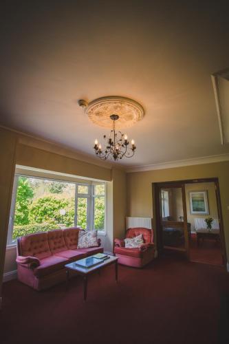 a living room with a pink couch and a chandelier at Diamond Hill Country House in Waterford