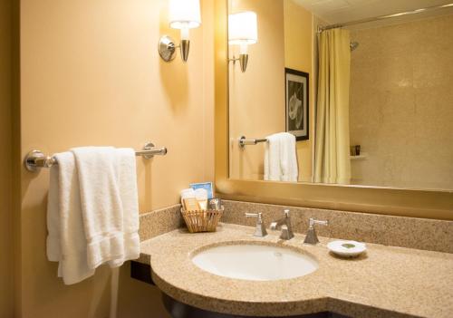 een badkamer met een wastafel en een spiegel bij Pacific Palms Resort and Golf Club in La Puente