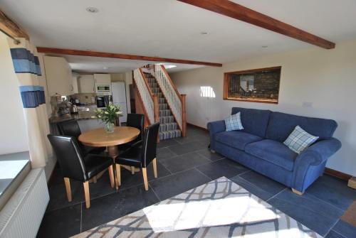 ein Wohnzimmer mit einem blauen Sofa und einem Tisch in der Unterkunft Lakeview Cottage in Callington