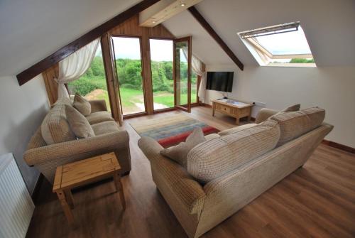 a living room with two couches and a table at Lakeview Cottage in Callington