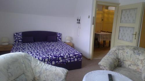 a bedroom with a bed and a couch and a table at Byt - apartman in Větřní
