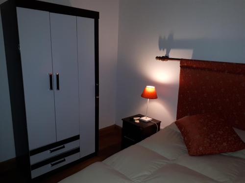 a bedroom with a white closet and a bed with a lamp at Posada del Angel in Colonia del Sacramento