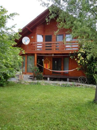 uma casa de madeira com um alpendre e um quintal em The Wooden House em Moldoveneşti