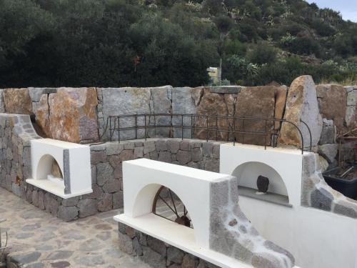 a stone wall with two archways in front of it at B&B da Luca in Panarea